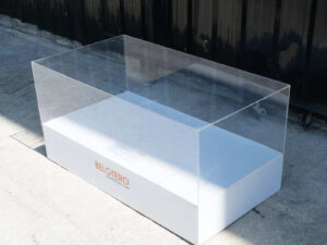 Clear acrylic product display shelf, white wooden frame, wide horizontal.