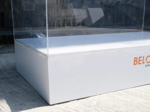 Clear acrylic product display shelf, white wooden frame, wide horizontal.