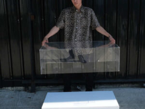 Clear acrylic product display shelf, white wooden frame, wide horizontal.