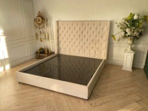 Bed 6 feet, wooden frame, fabric covered, cream color.