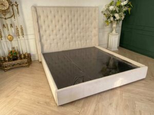Bed 6 feet, wooden frame, fabric covered, cream color.