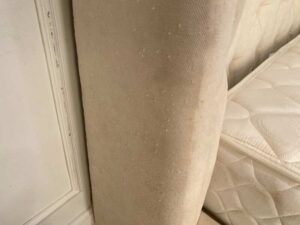 Bed 6 feet, wooden frame, fabric covered, cream color.