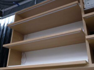 Product shelves, 2 sides, brown wooden frame. The bottom has 4 storage drawers on each side.