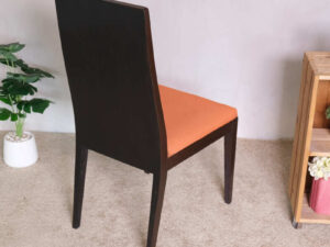 Wooden chair, orange fabric cushion, beautiful frame, slightly curved backrest.