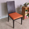Wooden chair, orange fabric cushion, beautiful frame, slightly curved backrest.