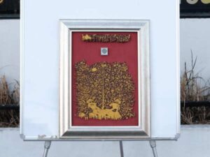 Picture of a golden forest with a red background, silver frame