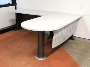 Executive desk, L-shaped corner, light gray wood top, steel legs, has a steel plate to shield the view under the desk, brand UB.