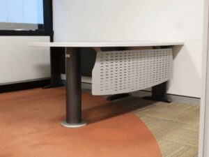 Executive desk, L-shaped corner, light gray wood top, steel legs, has a steel plate to shield the view under the desk, brand UB.
