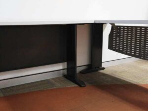 Executive desk, L-shaped corner, light gray wood top, steel legs, has a steel plate to shield the view under the desk, brand UB.