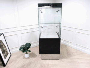 Tall glass product display cabinet, black color, glass door opening.