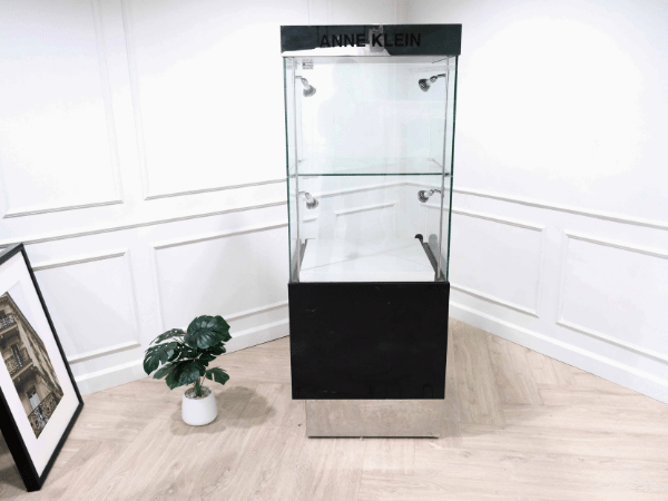 Tall glass product display cabinet, black color, glass door opening.