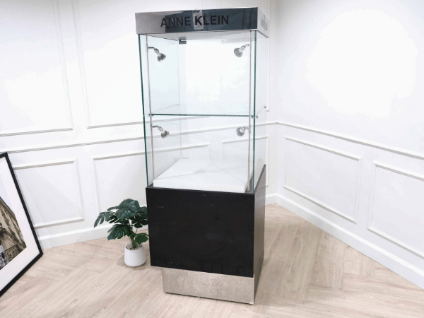 Tall glass product display cabinet, black color, glass door opening.