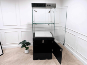 Tall glass product display cabinet, black color, glass door opening.