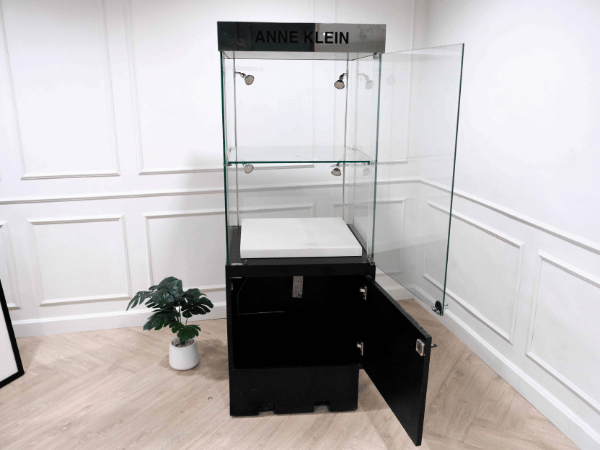 Tall glass product display cabinet, black color, glass door opening.