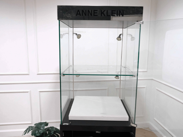Tall glass product display cabinet, black color, glass door opening.