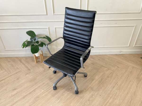 Office chair with black leather upholstery, high back, steel frame, steel arms and legs, adjustable height-low.