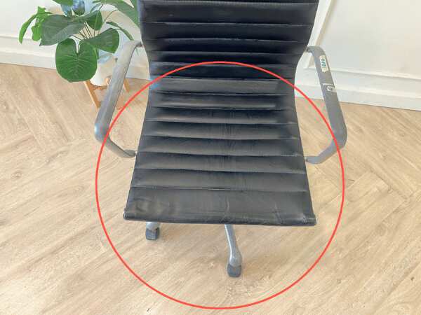 Office chair with black leather upholstery, high back, steel frame, steel arms and legs, adjustable height-low.