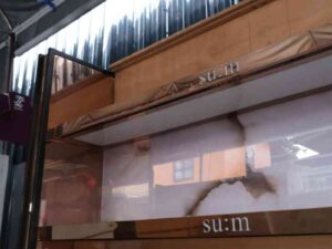 Product shelves, 2 sides, 2 shelves on each side, 2 drawers, wooden frame with gold stainless steel edges. There is a light sign on the side.