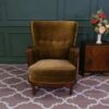 High backed lounge chair with pull pins, fabric cushion, dark green. European work comes from Germany.