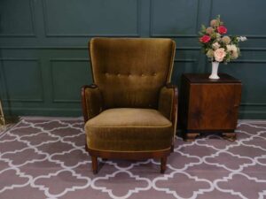 High backed lounge chair with pull pins, fabric cushion, dark green. European work comes from Germany.