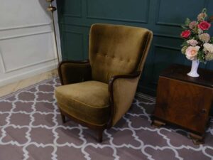 High backed lounge chair with pull pins, fabric cushion, dark green. European work comes from Germany.
