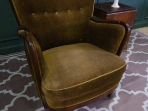 High backed lounge chair with pull pins, fabric cushion, dark green. European work comes from Germany.