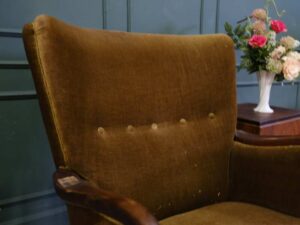 High backed lounge chair with pull pins, fabric cushion, dark green. European work comes from Germany.