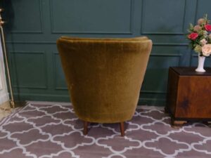 High backed lounge chair with pull pins, fabric cushion, dark green. European work comes from Germany.