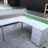 L-shaped corner desk with light gray filing cabinet and partition.