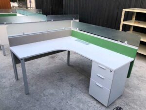 L-shaped corner desk with light gray filing cabinet and partition.