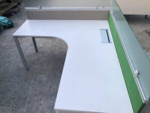 L-shaped corner desk with light gray filing cabinet and partition.