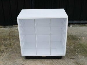 White wooden frame shelving unit with plastic shelves, 15 compartments.