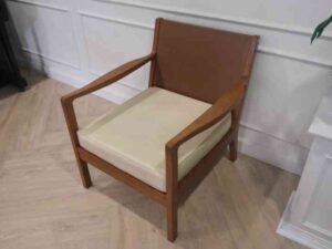 Chair with armrests, wooden frame. Seat cushion made of fabric.