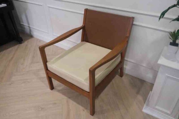 Chair with armrests, wooden frame. Seat cushion made of fabric.