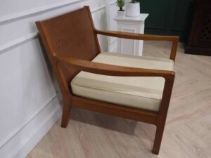 Chair with armrests, wooden frame. Seat cushion made of fabric.