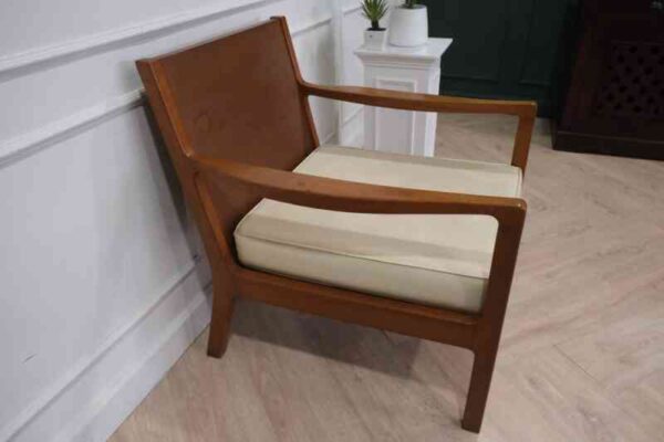 Chair with armrests, wooden frame. Seat cushion made of fabric.