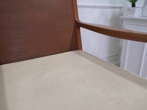 Chair with armrests, wooden frame. Seat cushion made of fabric.