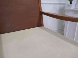Chair with armrests, wooden frame. Seat cushion made of fabric.