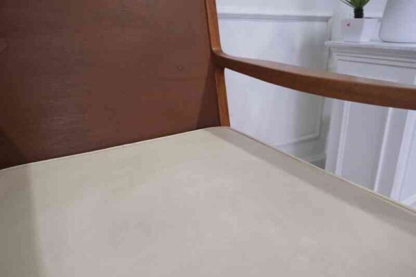 Chair with armrests, wooden frame. Seat cushion made of fabric.
