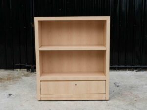 Product shelf, 2-level shelves, 2 storage cabinets with open doors, light brown wooden frame.