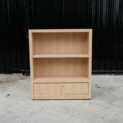 Product shelf, 2-level shelves, 2 storage cabinets with open doors, light brown wooden frame.
