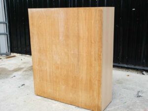 Product shelf, 2-level shelves, 2 storage cabinets with open doors, light brown wooden frame.