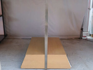Product shelves, display stands, 2 sides, brown wooden base. Has a drawer in front of a mirror and has wheels
