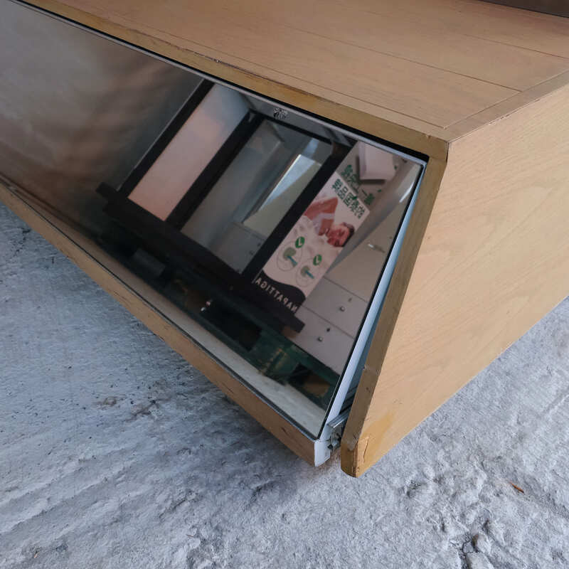 Product shelves, display stands, 2 sides, brown wooden base. Has a drawer in front of a mirror and has wheels