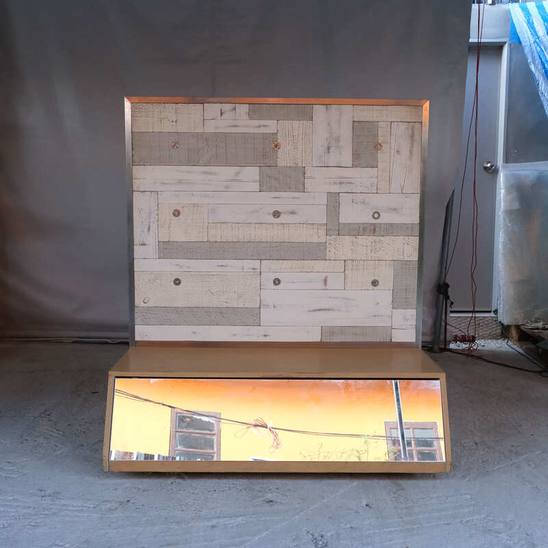 Product shelves, display stands, 2 sides, brown wooden base. Has a drawer in front of a mirror and has wheels