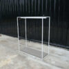 Open product shelves, with a hanging rail at the top. white steel frame Brown wood pattern base