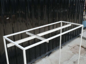 Open product shelves, with a hanging rail at the top. white steel frame Brown wood pattern base