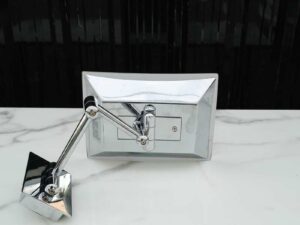 Shaving mirror in the bathroom, wall mounted, has built-in lights, steel cantilever legs.