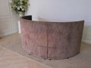 Semi-circular reception counter, cloth covered, wooden frame, brown.