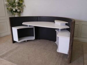Semi-circular reception counter, cloth covered, wooden frame, brown.
